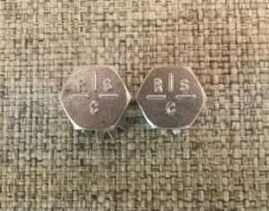 Two metal octagonal tokens with "RIS C" inscription.