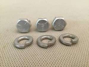 Hex nuts and washers on fabric surface.