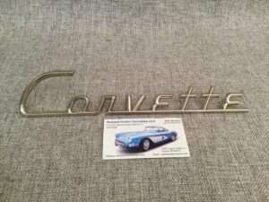 Corvette emblem and business card on fabric surface.