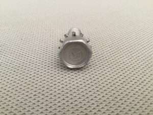 Metal screw on textured surface.