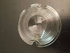 Clear glass ashtray on dark surface.