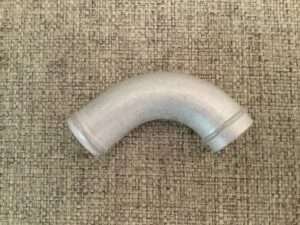 PVC elbow pipe fitting on textured background