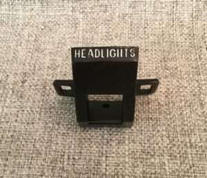 Black camera headlight clip on textured background.