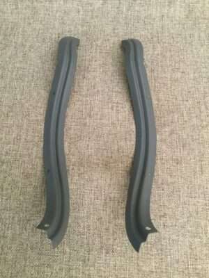 Two black car door guards on gray carpet.
