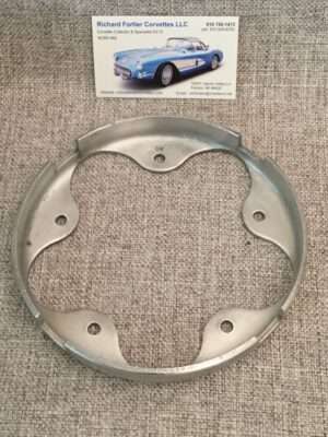 Metal car part and business card on fabric.