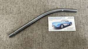 Metal car part and business card on fabric.