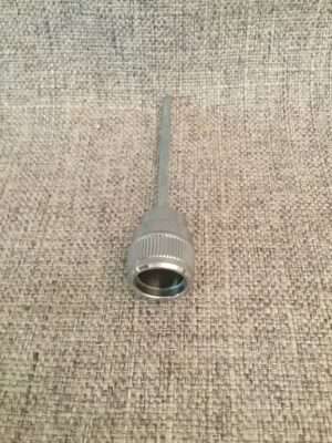 Metal coaxial cable tool on textured background.