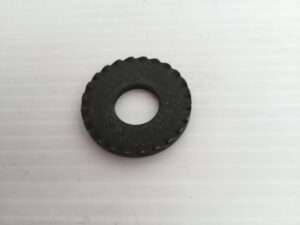 Black serrated washer on white surface.