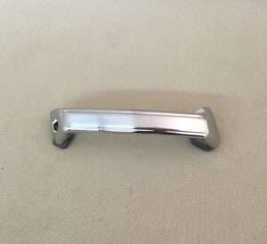 Silver cabinet handle on beige surface.