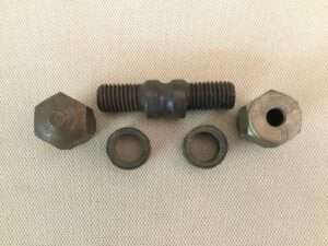 Bolt, two nuts, and washers on light background