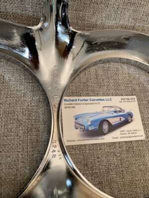 Shiny car part with a business card on fabric surface.