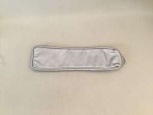 Gray satin sleep mask on fabric surface.
