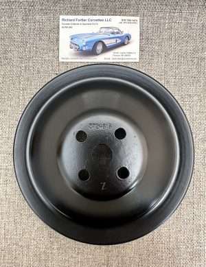 Black hubcap and business card on textured surface.