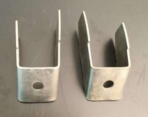 Two metal brackets on gray background.