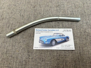 Metal tool and business card on fabric surface.